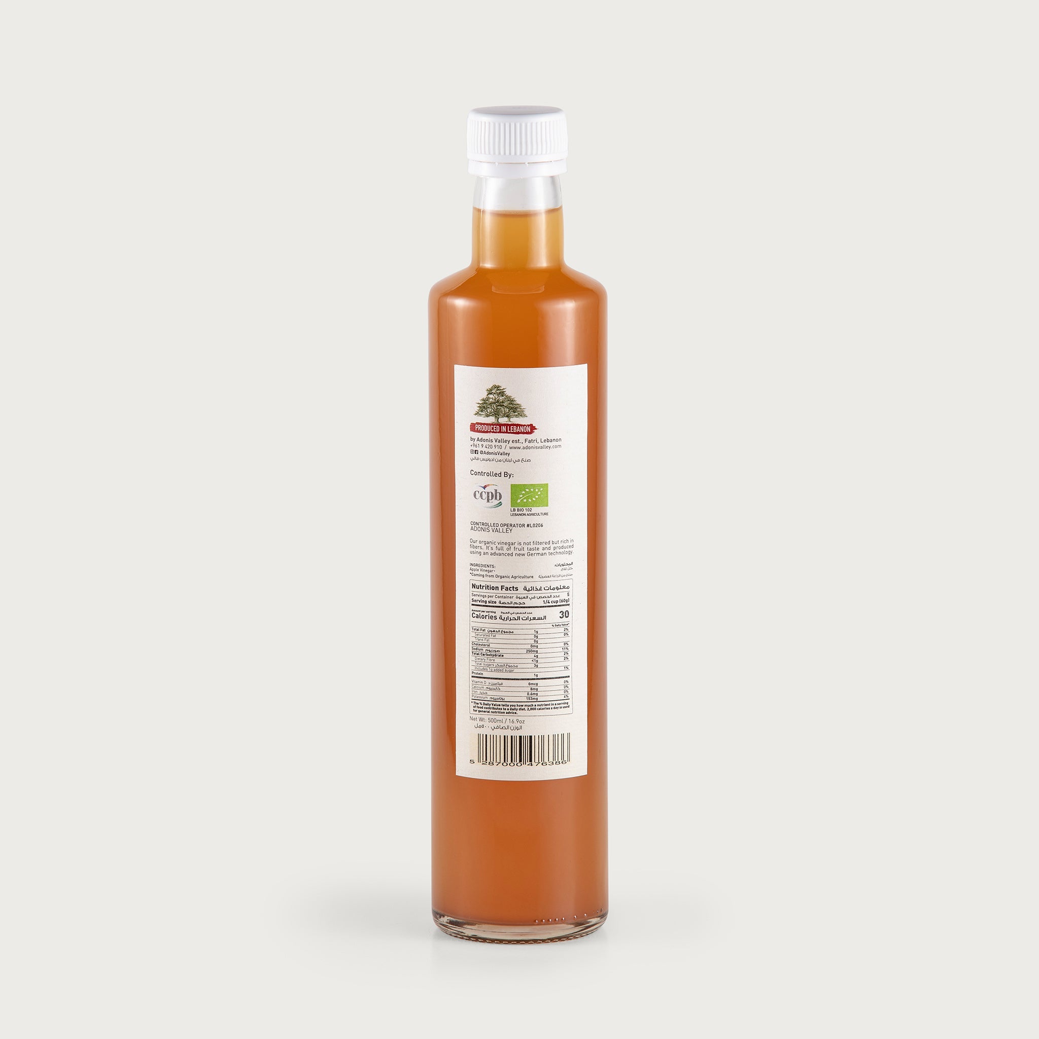 A tall 17 oz. clear bottle shows the rich, golden amber colored apple vinegar. The label is white with an illustration of apples on a branch. The label denotes this product is not filtered.