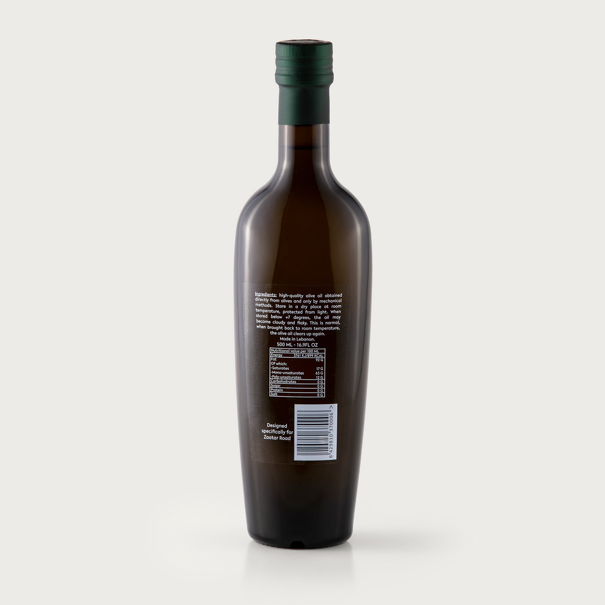 This 16.9 oz bottle of premium filtered olive oil is dark olive in color so it protects the liquid inside. The white MIMAS logo is included on the bottle, with the latitude and longitude 33.3N, 35.5 E, Made in Lebanon, Village of Dier Mimas.